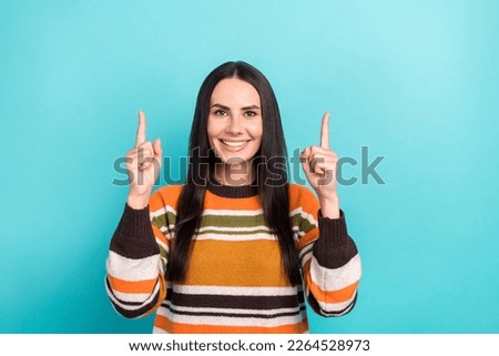Photo of cheerful young promoter indicate fingers up useful information get free delivery over price isolated on aquamarine color background