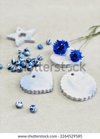 DIY crafts accessories with concrete shapes like hearts, stars, cornflowers and blue clay beads