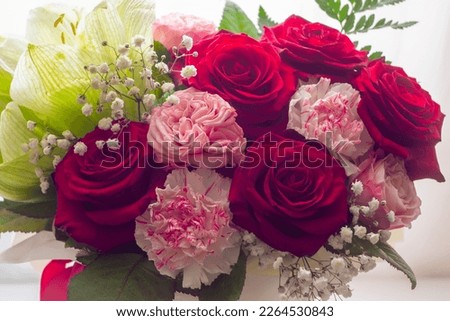 
A bouquet of flowers with red roses as a gift for the holiday.