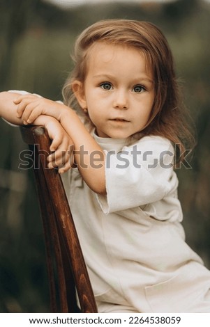 cute portrait of a 3-year-old girl in cloudy weather on a natural background by the river Royalty-Free Stock Photo #2264538059