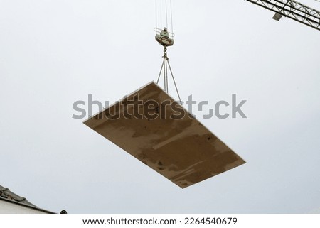 Precast concrete floor hanging on a mobile crane in the air Royalty-Free Stock Photo #2264540679