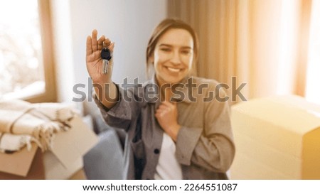 A young girl moved to a new house. The happy woman holds the keys to the new house in her hands. Royalty-Free Stock Photo #2264551087