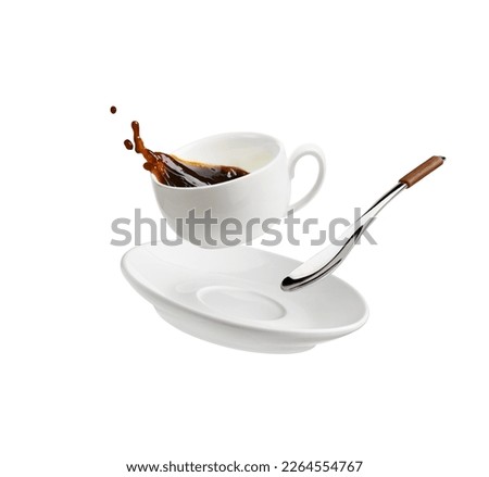 Cup of coffee with a splash drop fly with saucer and spoon isolated on white