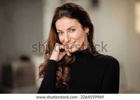 Close-up portrait of an attractive brunette haired woman looking at camera and cheerful smiling.  Royalty-Free Stock Photo #2264559969