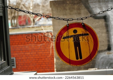 Stop sign with human silhouette in red circle on the buildings background