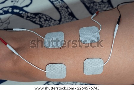 Spark up your fitness routine with electrostimulation, Unleashing the power of electrotherapy on my leg, Wired for strength Royalty-Free Stock Photo #2264576745