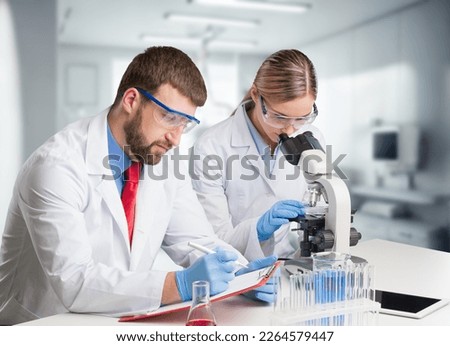 Young smart scientist working with microscope in the lab