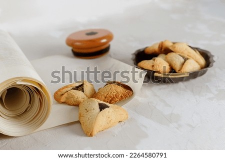 Scroll of Esther and haman's ears cookies. Concept Jewish holiday Purim.
