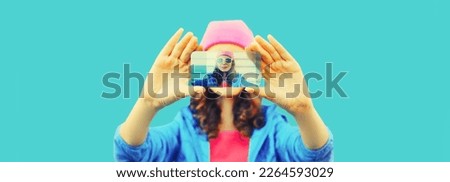 Close up of modern young woman stretching her hands taking selfie with smartphone on blue background
