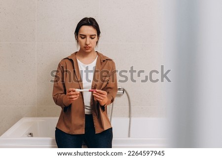 Pregnant young girl waiting for the result of a pregnancy test.