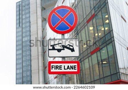 Road sign - No stopping, fire passage, against the backdrop of a business center.