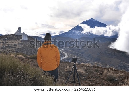 Young man taking picture of teide volcano in tenerife, canary islands