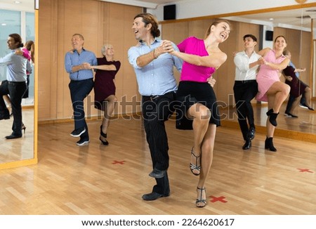 Couple of dancers rehearsing ballroom dances in dance studio