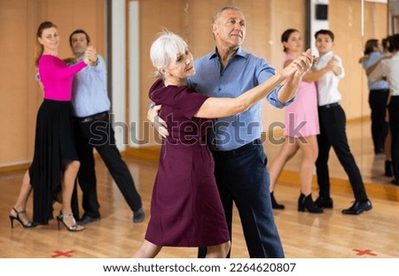 Positive active elderly couple enjoying slow foxtrot in dance studio. Amateur social dancing concept Royalty-Free Stock Photo #2264620807