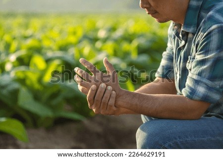 Injuries or Illnesses that can happen to farmers while working. Man is using his hand to cover and press on hand because of hurt,  pain or feeling ill. Health of agriculturist concept.
