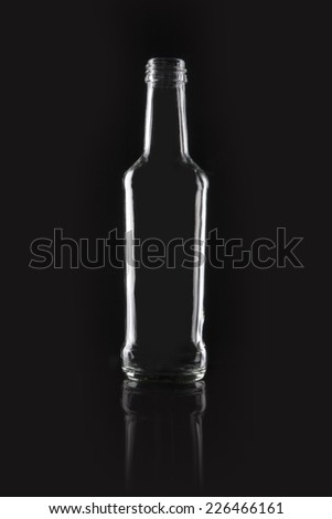 A  transparent glass empty container on the reflective bottom isolated black. 