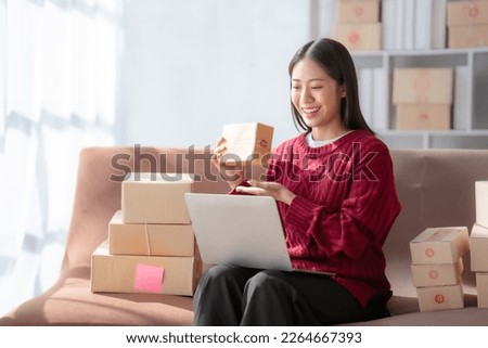 Attractive young chinese SME owners woman entrepreneurs working on receipt box and check online orders, SME home business ideas online.