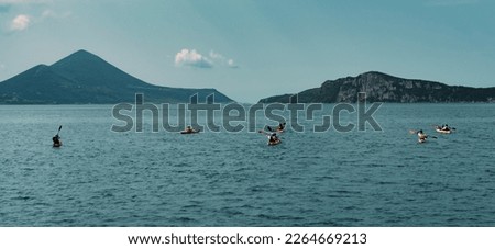 canoe trip in the sea , mountains shore, tourist group making water sports