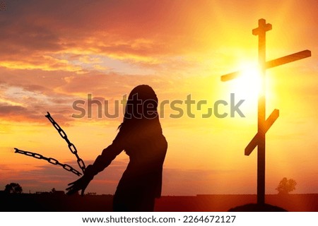 Silhouette of woman break chains with Holy Cross on background