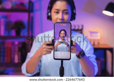 Vlogger live streaming podcast review on social media, Young Asian woman use microphones wear headphones with smartphone record video. Content creator concept. Royalty-Free Stock Photo #2264677643