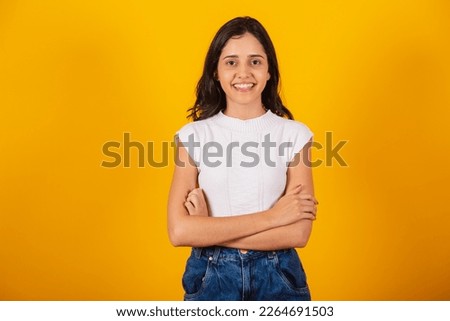 Brazilian woman, arms crossed smiling.