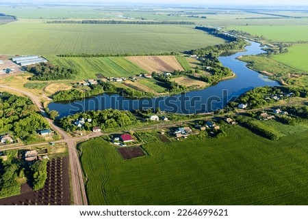 view from a height to the green fields of crops, the pond for irrigation, the sun's glare and tinting,. High quality photo