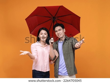 Young Asian couple with umbrella on background