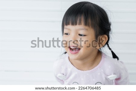 Portrait Asian little sweet girl wearing casual clothes, smiling and laughing with happiness, standing alone in indoor home or studio with copy space. Kid, Health care, Education Concept Royalty-Free Stock Photo #2264706485