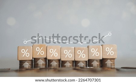 Place the silver coin with the up arrow and the percentage symbol on the wooden block. The concept of interest rates and dividends. financial and growth stocks financial investment business Royalty-Free Stock Photo #2264707301