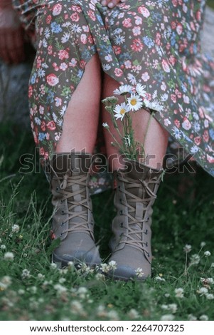 Field daisies in a woman's shoes