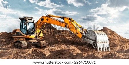 A large yellow crawler excavator moving stone or soil in a quarry. Heavy construction hydraulic equipment. excavation. Rental of construction equipment Royalty-Free Stock Photo #2264710091