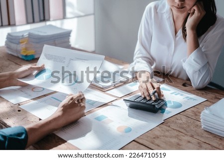 Team of asian people taxation bookkeeper consulting with friends analyzing balance sheet company annual financial report, tax of stock market statement in modern office. using calculator Royalty-Free Stock Photo #2264710519