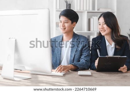Two asia business person in formal suit working in office together , stock trader trading in computer together, bookkeepers working with online balance sheet, asset, profit or loss of limited company Royalty-Free Stock Photo #2264710669