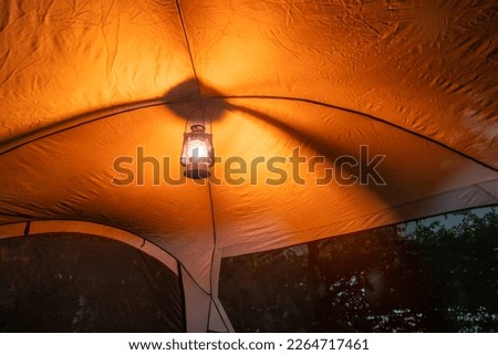 antique oil lamp Light inside the camping tent at night in the pitch dark forest, selective focus, soft focus. Royalty-Free Stock Photo #2264717461