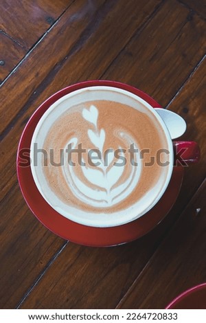 a picture of coffee latte art using a red cup