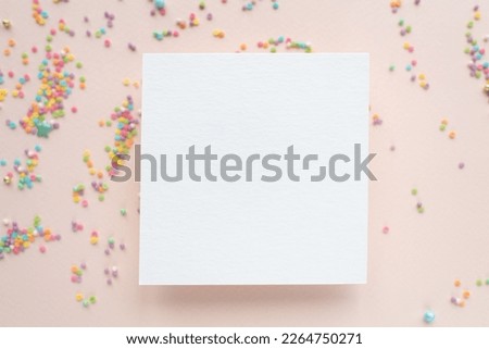 white paper mockup with texture on festive peach background with confetti, invitation mockup, top view