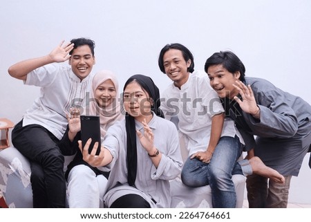 Young muslim people taking selfie or having video call during eid mubarak moment Royalty-Free Stock Photo #2264764661