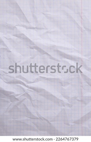 Sheet of crumpled checkered paper as background, top view