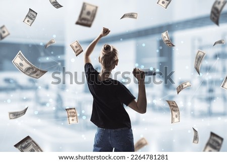 Back view of oung successful woman with dollar bill money rain on blurry office interior background. Success, money and lottery winner concept