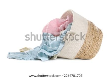Overturned laundry basket full of clothes isolated on white Royalty-Free Stock Photo #2264781703