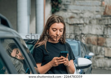 young woman chatting with the phone in the street