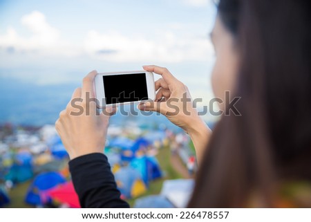 Woman using smart phone take a photo during on top of mountain in northern on Thailand.