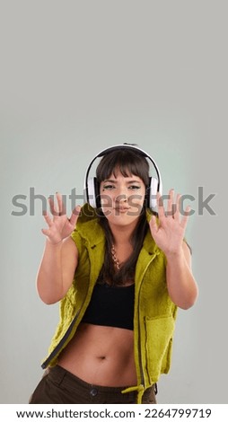 Music, dance and portrait of woman with headphones in studio, happy and excited isolated on grey background. Streaming service, song and gen z fashion, girl dancing with hands up to online radio dj.