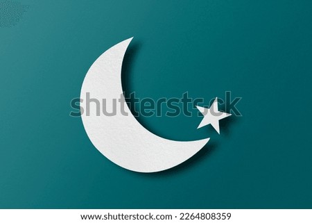 White paper cut into crescent shapes and stars set on green paper background.