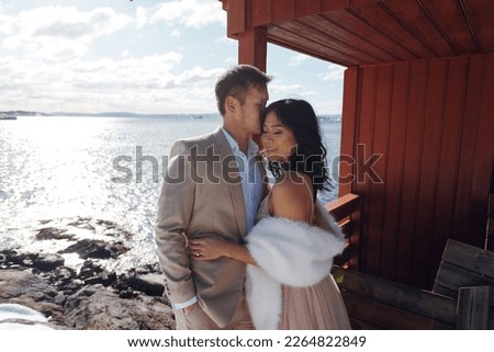 Enamoured bride and groom posing in the beautiful winter place together. Woman and husband kissing each other. Stock photo Royalty-Free Stock Photo #2264822849