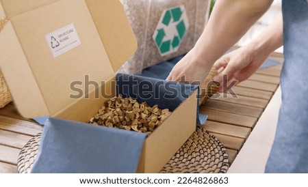 Eco vendor go green packaging parcel carton box in net zero waste store asian seller retail shop. Earth care day small SME owner asia people wrap reuse brown paper pack gift reduce plastic free order.