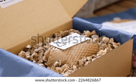 Net zero waste go green SME use eco friendly care sign plastic free symbol packaging carton box wrap paper in small shop retail store. Chva dried water hyacinth on desk reuse packing parcel supplies. Royalty-Free Stock Photo #2264826867