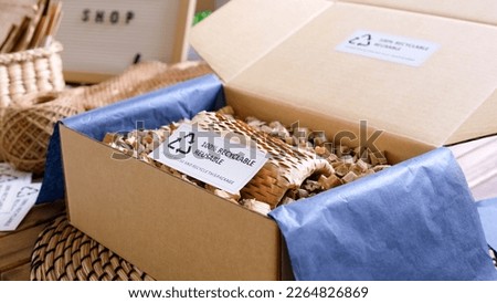 Net zero waste go green SME use eco friendly care sign plastic free symbol packaging carton box wrap paper in small shop retail store. Chva dried water hyacinth on desk reuse packing parcel supplies. Royalty-Free Stock Photo #2264826869