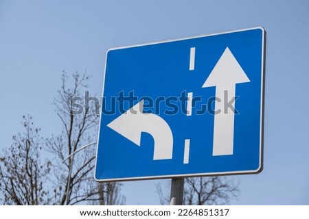 Go straight direction traffic sign on sky background. Direction of road signs for cars. Turn left - symbol for safety driving 