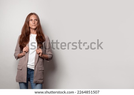 Beautiful confident serious business woman standing against white banner background